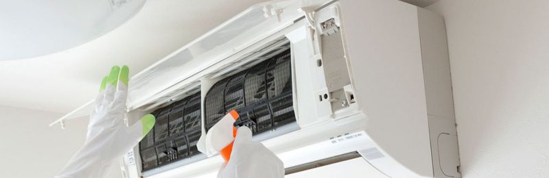 AC technician repairing an air conditioner unit in Bonita CA